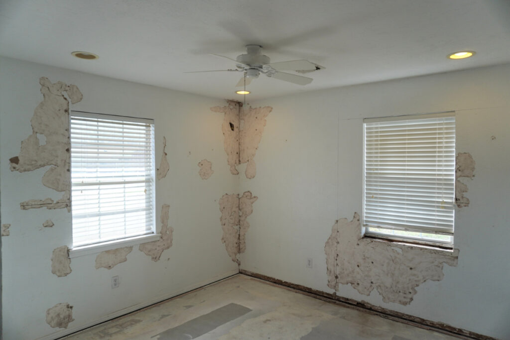 Room with peeling paint and bare floor.